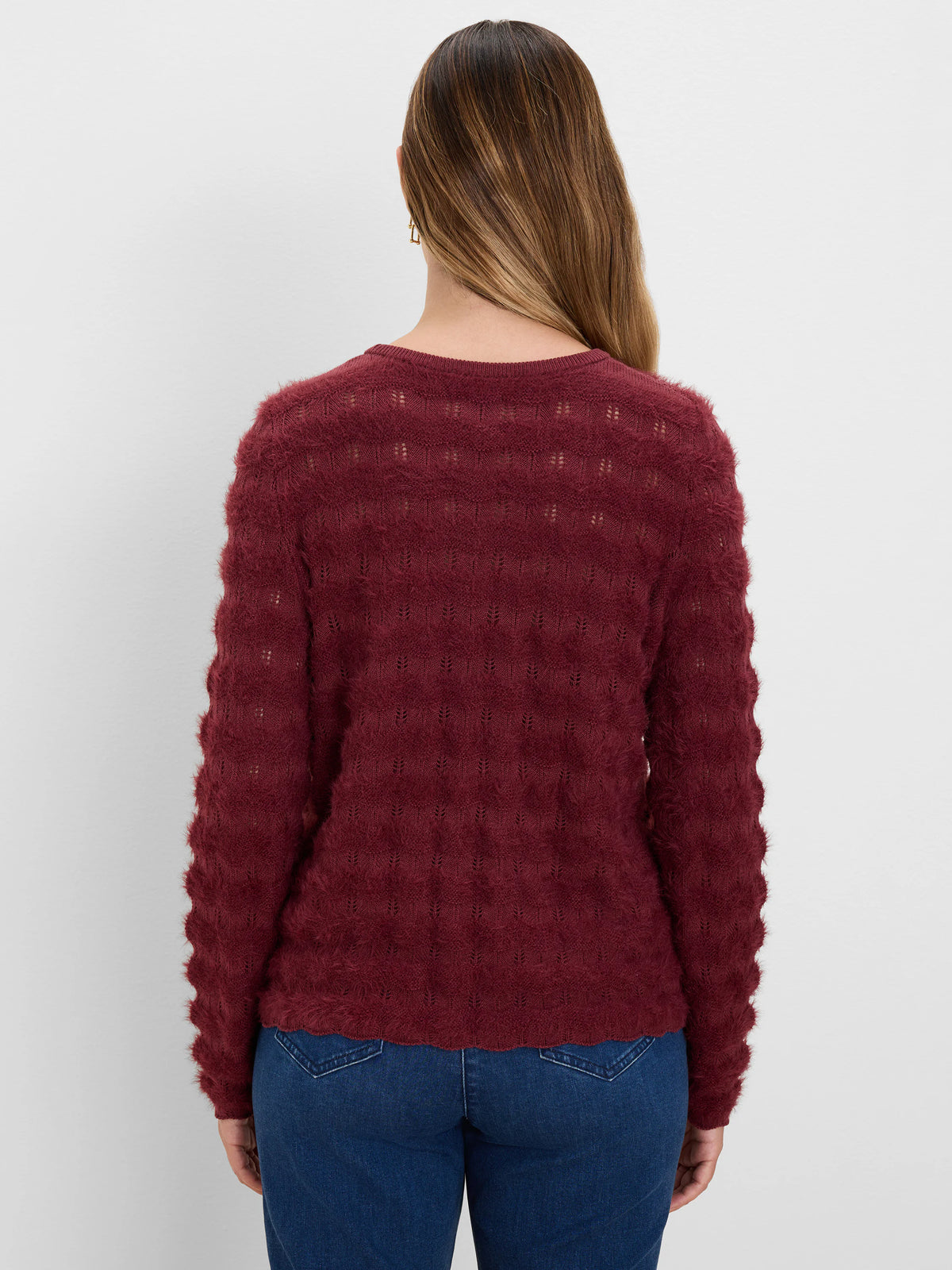 Maroon fuzzy sweater with a subtle open-knit leaf pattern on the back, long sleeves, and a round neckline.