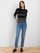 Black sweater with horizontal white dotted stripes; white striped cuffs and hem.