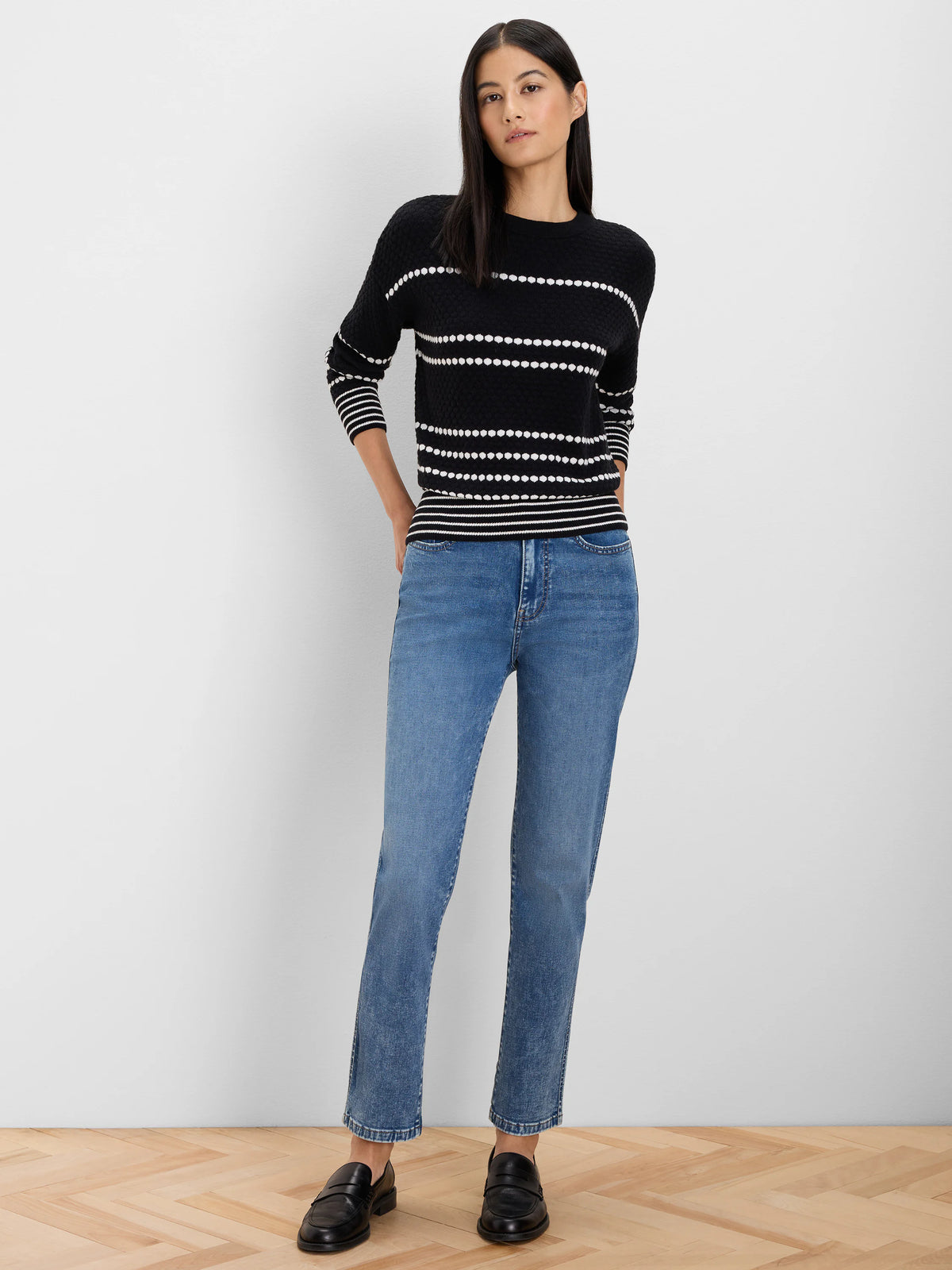 Black sweater with horizontal white dotted stripes; white striped cuffs and hem.