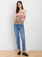 Pale pink knit sweater with black dotted horizontal stripes and solid black cuffs/hem.