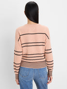 Textured peach sweater with black dotted stripes on the back and sleeves, ribbed hem and cuffs.