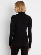 Black, ribbed knit turtleneck with long sleeves. Worn by a model.