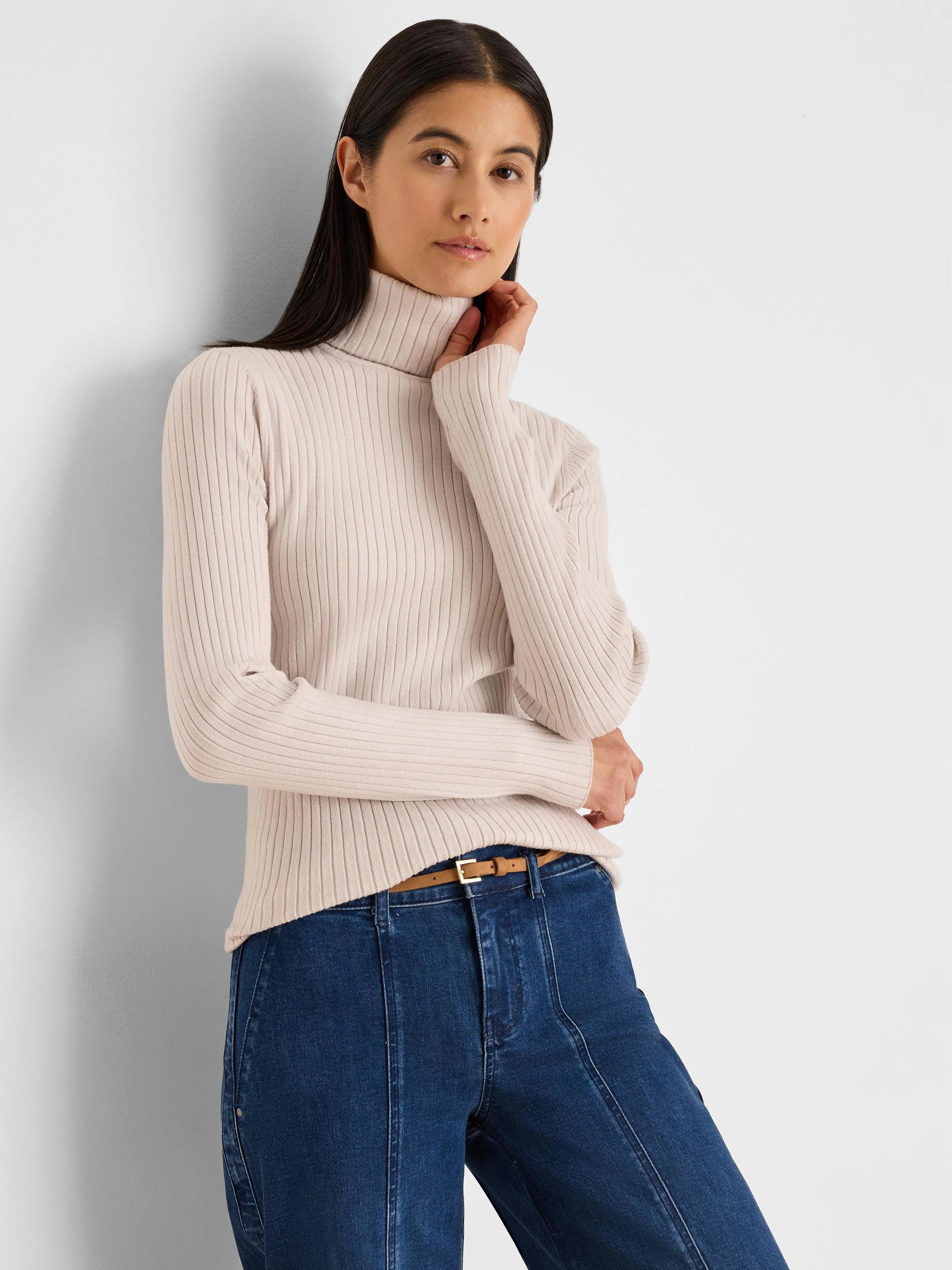 Light beige fitted knit turtleneck with prominent vertical ribbing.