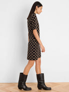 Black and tan geometric knit dress with short sleeves, mock neck, and above-knee length.
