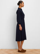 Dark blue knit eyelet midi dress with ruffled high neck, long sleeves, and cinched waist.