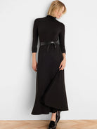 Black high neck maxi dress with 3/4 sleeves and a thin black tie belt. Skirt features a diagonal front drape.