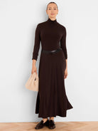 Dark brown high neck maxi dress with long sleeves and a flowing A-line skirt.