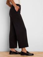 Black wide-leg ankle pants with folded cuffs, a smooth fabric, and a visible side pocket detail.