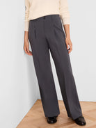 Charcoal wide-leg trousers with front pleats, two visible black buttons at the waist, and smooth fabric.