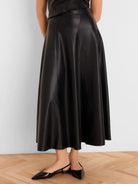 Black vegan leather seamed midi skirt, A-line and flared.