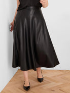 Black, seamed vegan leather skirt, mid-calf length with a flared silhouette.