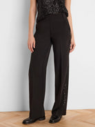 Black tuxedo pants with black sequin stripes on the outer seams.
