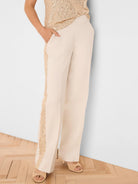 Cream wide-leg pants with a gold sequin tuxedo stripe.