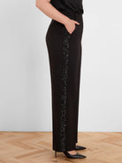 Black straight-leg pants with a vertical black sequin stripe down the outer side seam.