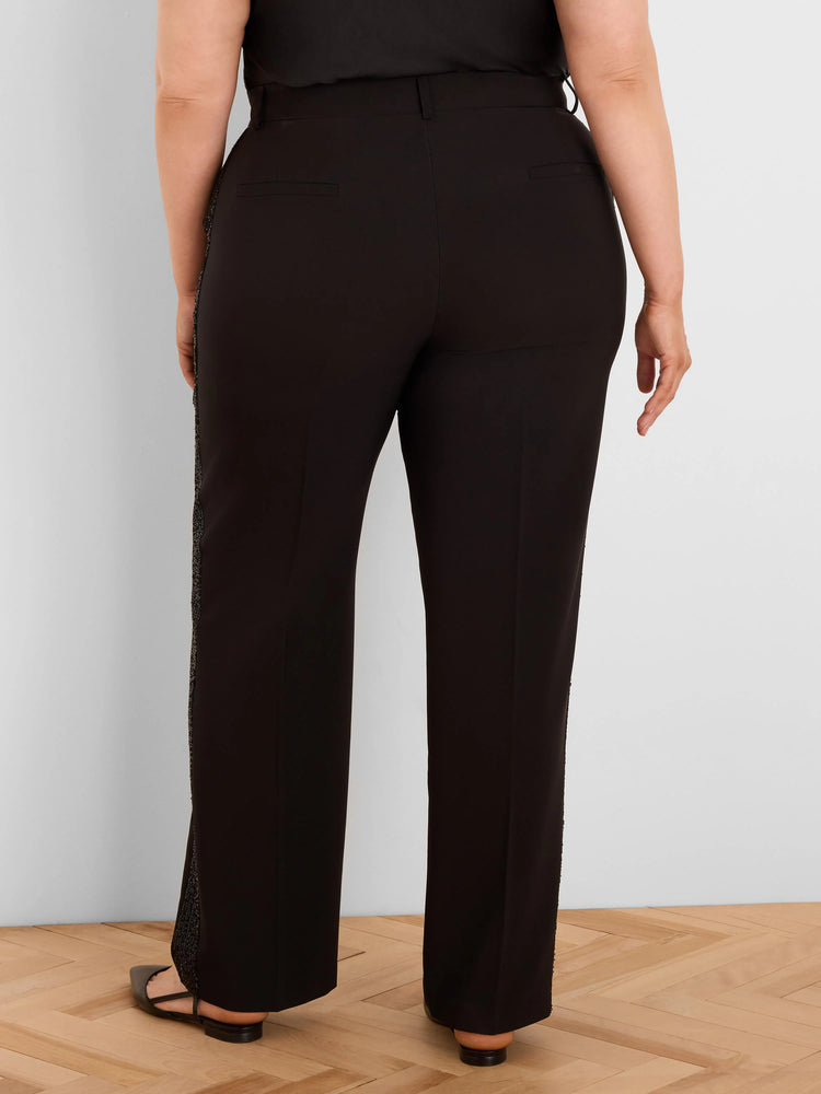 Black tuxedo pants, seen from behind, with dark sequin stripes along the outer seams of each leg.