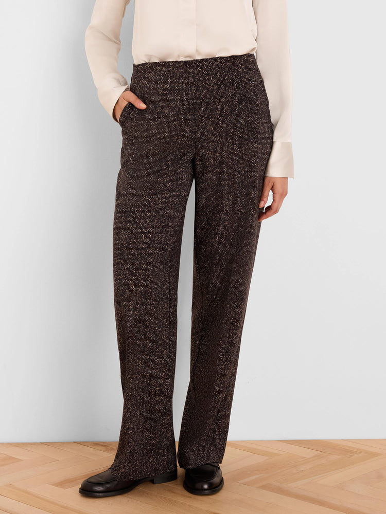 Dark brown wide-leg pants with a tan flecked print. A hand is in the front pocket.