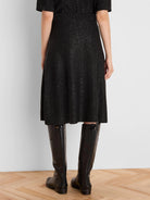 Black A-line sequin knit skirt, mid-calf length, with a ribbed waist, sparkling all over.