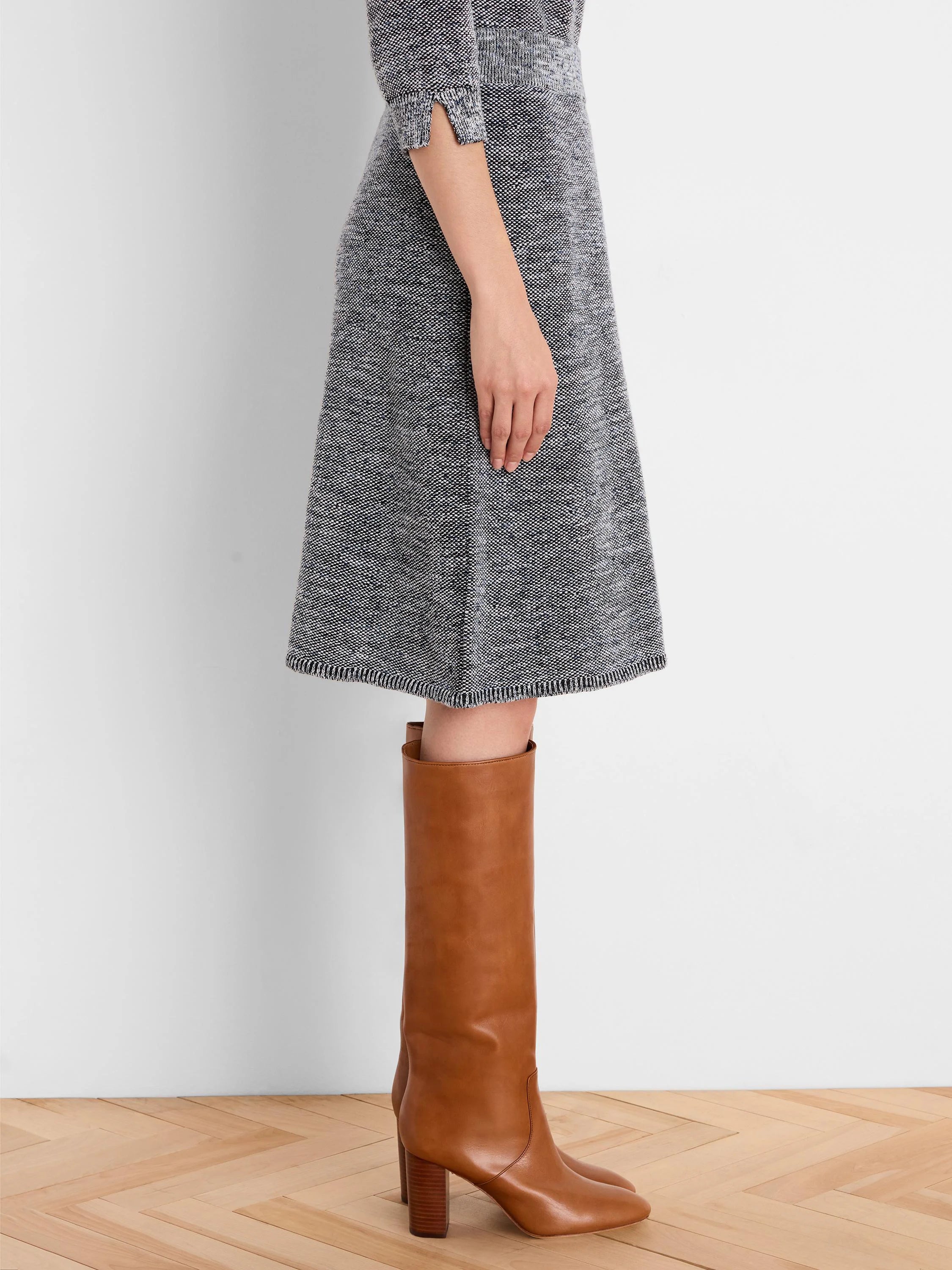 Knee-length A-line skirt with dark grey, white & blue tweed knit pattern and a ribbed hem.