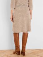 Speckled beige knit skirt, knee-length, with ribbed waistband and hem.