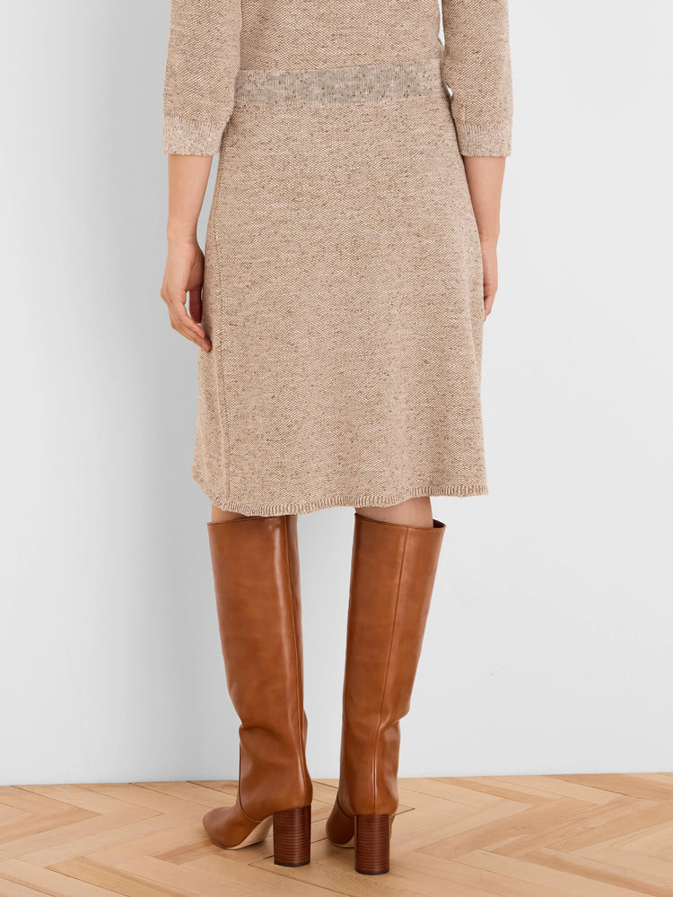 Speckled beige knit skirt, knee-length, with ribbed waistband and hem.