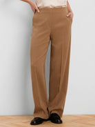 Camel wide-leg pants with a high, flat waist, side pockets, and a center leg crease.