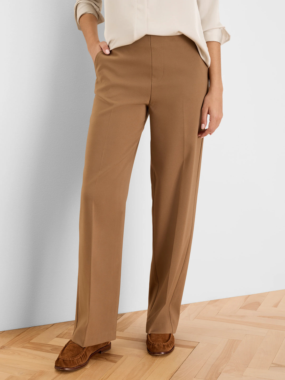 Brown wide leg pants, sleek fabric with subtle vertical creases. Model wears a cream top.