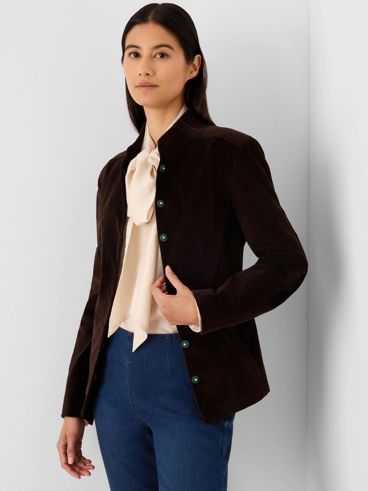 Dark brown velvet jacket with a stand collar, teal buttons, and a fitted silhouette.