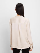 Back view of a light champagne glossy shirt with a collar, long sleeves, buttoned cuffs, back yoke, and pleat.