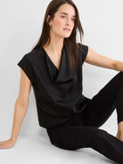 Black glossy tee with a draped cowl neck and short cap sleeves.