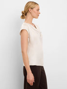Creamy drape neck gloss tee with short cap sleeves.