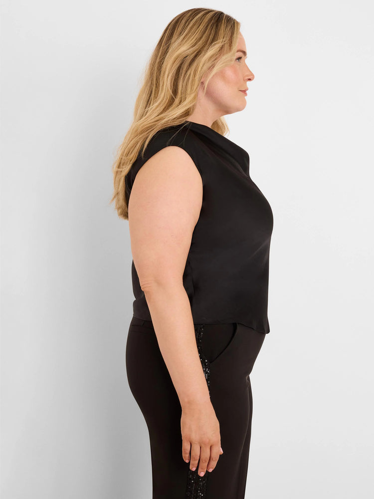 Black sleeveless top with a draped cowl neck and subtle glossy finish, worn by a woman in side profile.