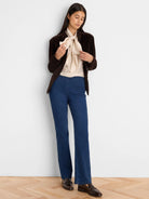 Cream crinkled top with a large, soft fabric bow tied at the neck.