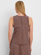 Sleeveless top, back view. Tan, navy, and reddish-brown geometric tile pattern. Round neck with back button closure.