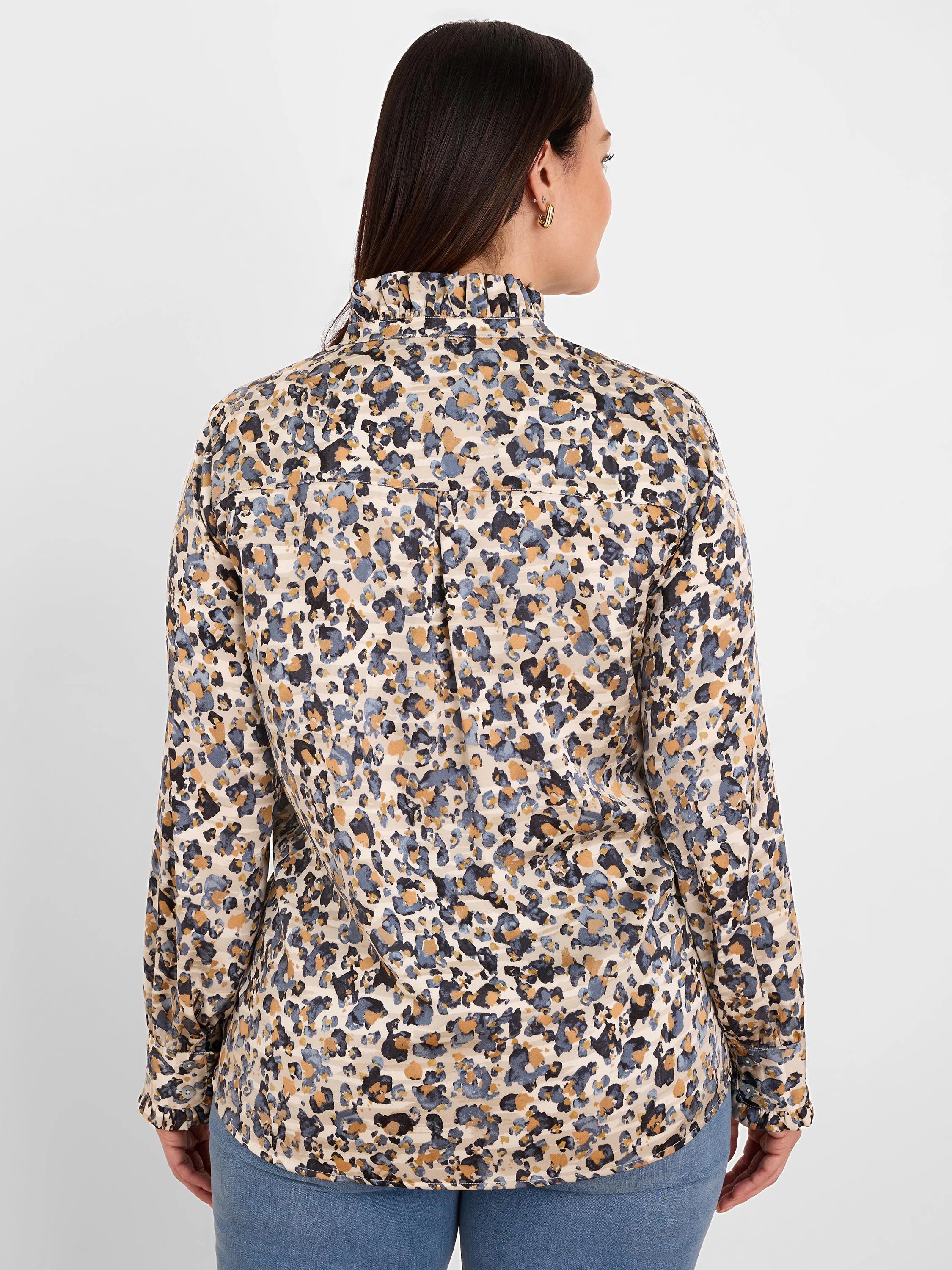 Back of a shirt with cream base, blue-gray, black, and gilded tan abstract spots. Features ruffled collar and cuffs.