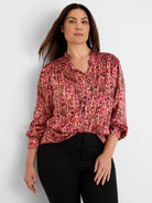 Origami Pleat Shirt: Red, pink, orange, black abstract print with fine vertical pleats, band collar, and gathered cuffs.