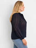 Navy blue shirt with an alternating sheer and opaque grid pattern, long sleeves, and a collared neckline.