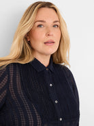 Sheer deep navy chiffon tuxedo shirt with a subtle grid jacquard pattern, vertical pleats, and white buttons.