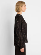 Black long-sleeve shirt with rose gold metallic diamond and vertical stripe patterns.