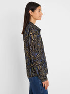 Dark chiffon shirt with blue, beige, and green paisley pattern. Collared, long-sleeved.