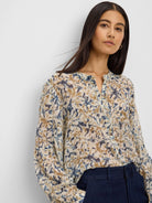 Cream chiffon shirt with abstract navy and golden brown print, long sleeves, and a band collar.