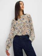 Cream chiffon shirt with abstract blue and brown pattern, band collar, long cuffed sleeves.
