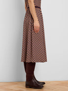 Midi skirt with tan, dark brown, and navy blue geometric tile pattern & striped waist.