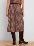 Midi skirt with a geometric tile pattern in beige, navy, and rust. Features a dark banded waist.