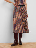 Midi pleated skirt with a geometric pattern of tan, navy, and rust tiles. Dark blue waistband.