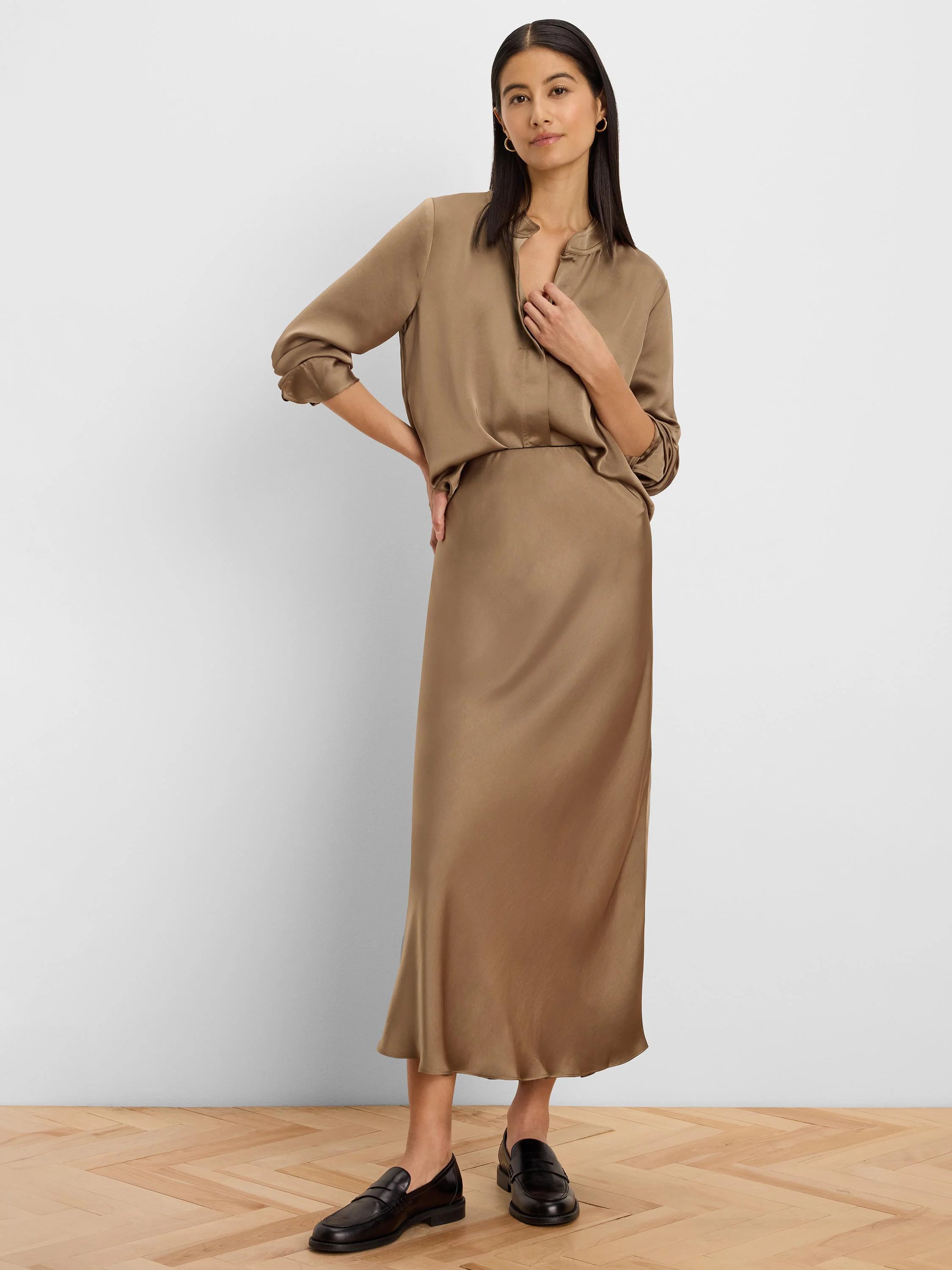 Brown glossy slip skirt, midi length, with a smooth, flowing drape.