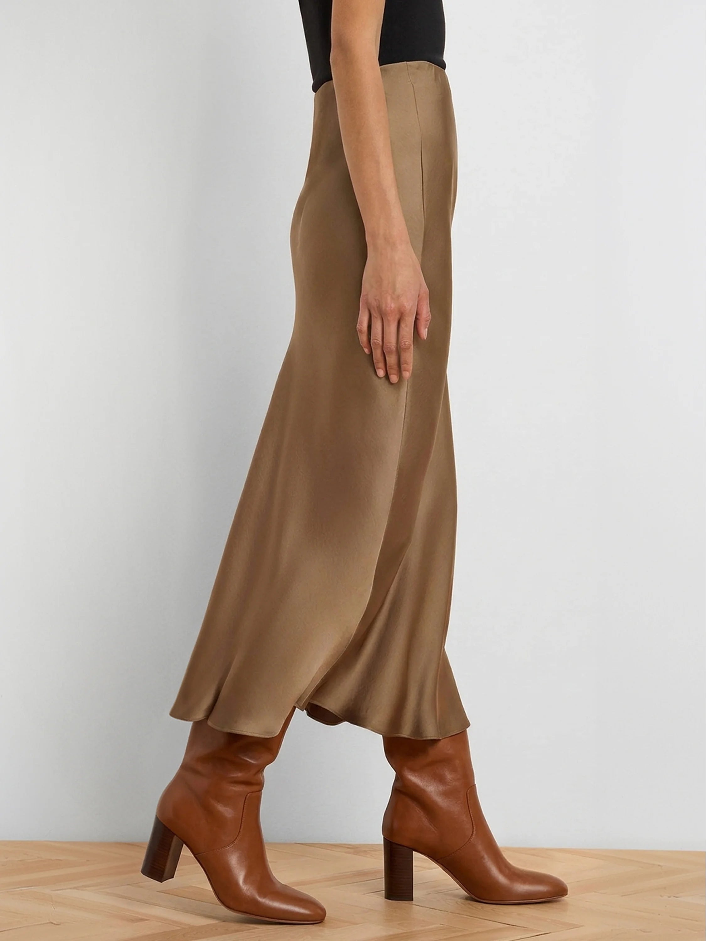 Tan, glossy slip skirt with a flowing midi length on a model.