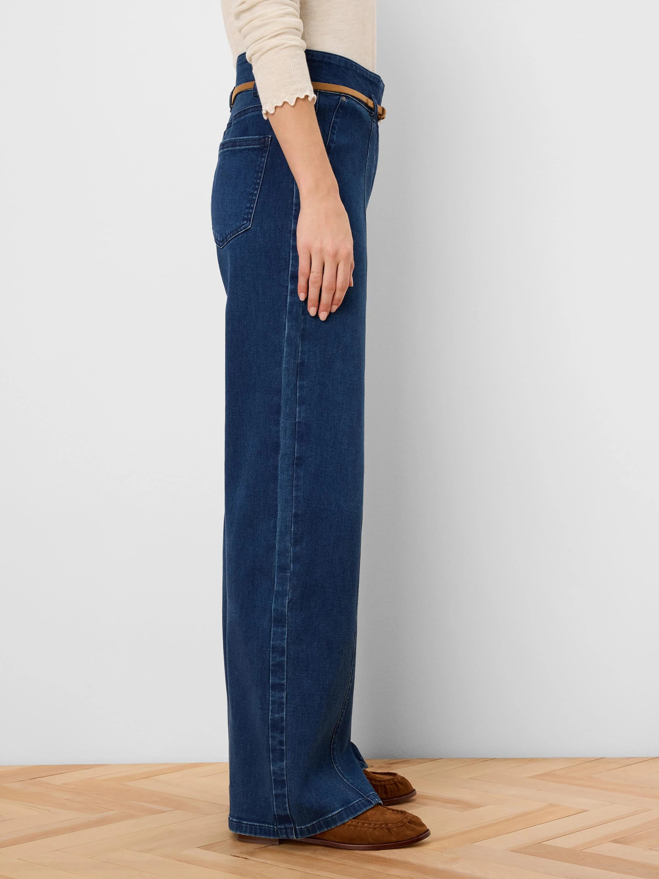 Dark blue wide leg jeans, side view. Features a thin tan belt at the high waist.