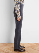 Dark grey velvet high-rise bootcut pants, shown from the side on a model.