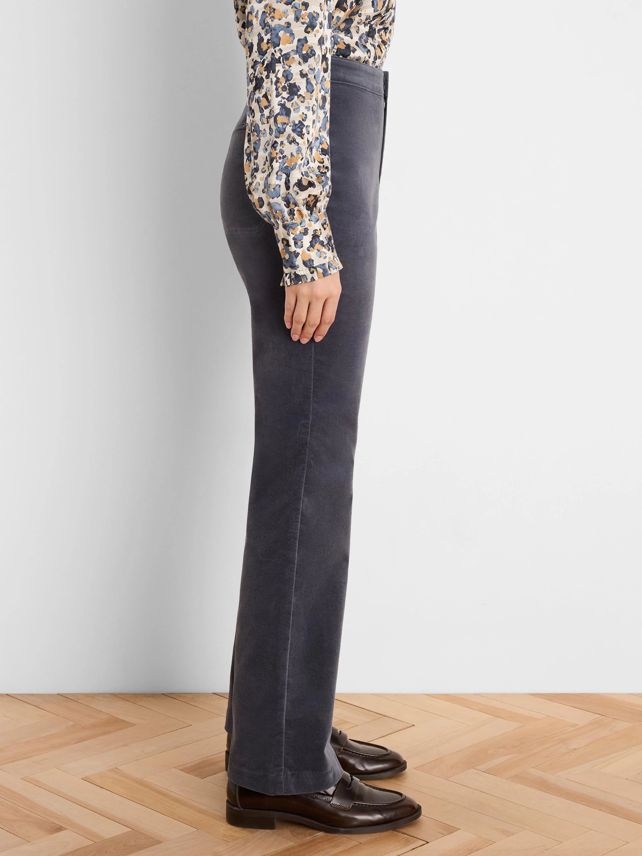 Dark grey velvet high-rise bootcut pants, shown from the side on a model.