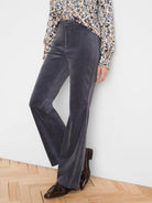 Charcoal high-rise velvet boot-cut pants, shown worn, flared hem covering shoes.